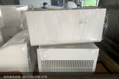 堆在木箱旁的箱体半成品：它们每多躺一天，交期就晚一天，被磕的机会就多一天